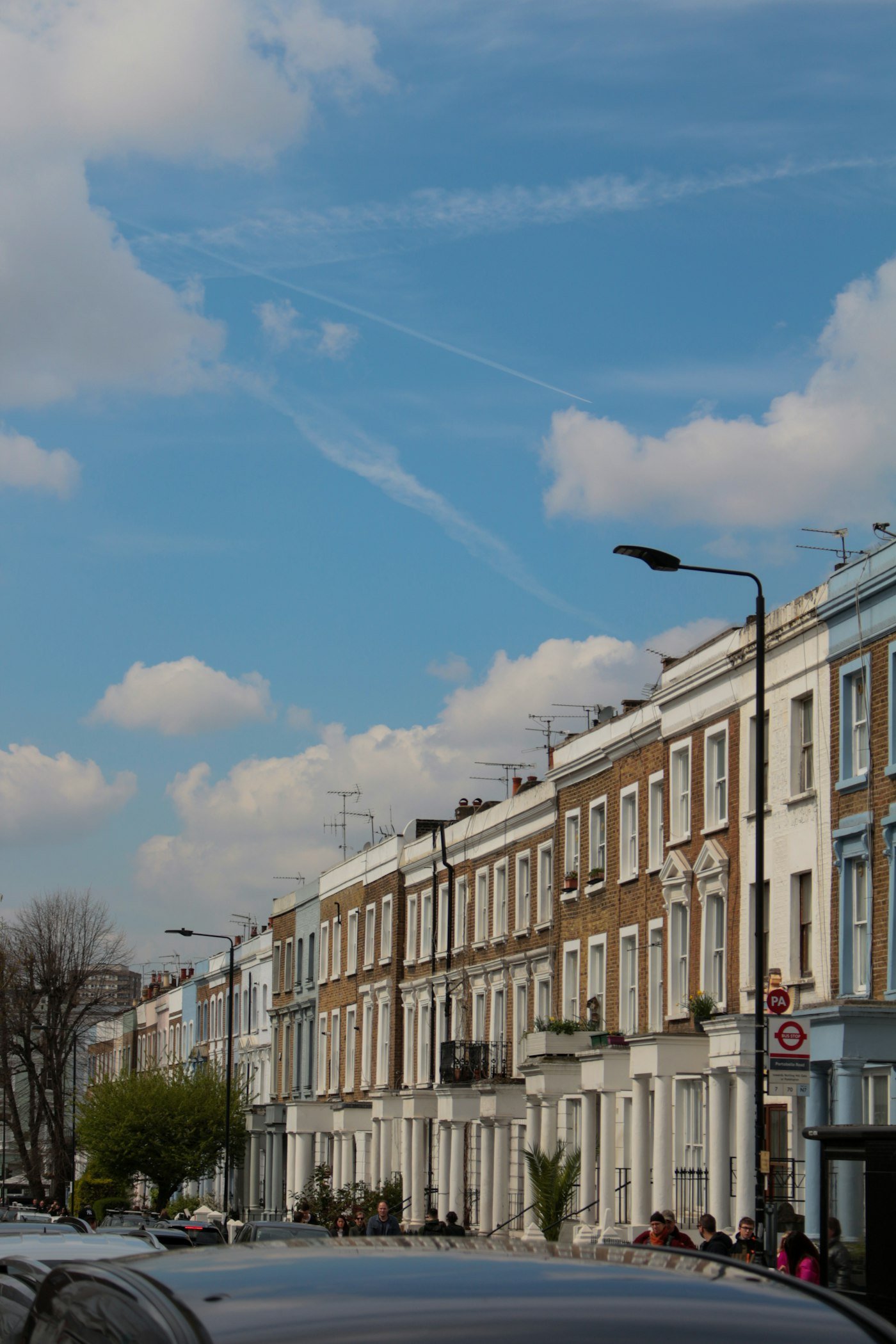 A row of London terraced houses under a blue sky
