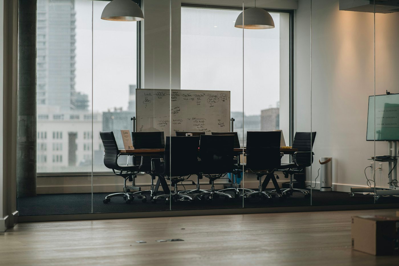 A quiet glass walled meeting room with a table and chairs