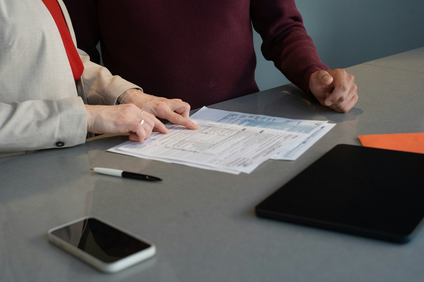 Two people going through a set of accounts at a table