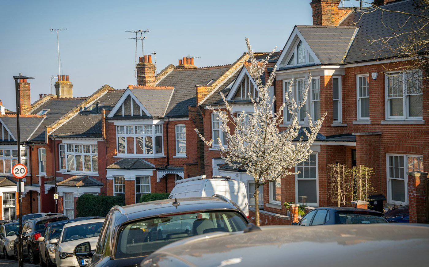 A street of terraced houses with front gardens