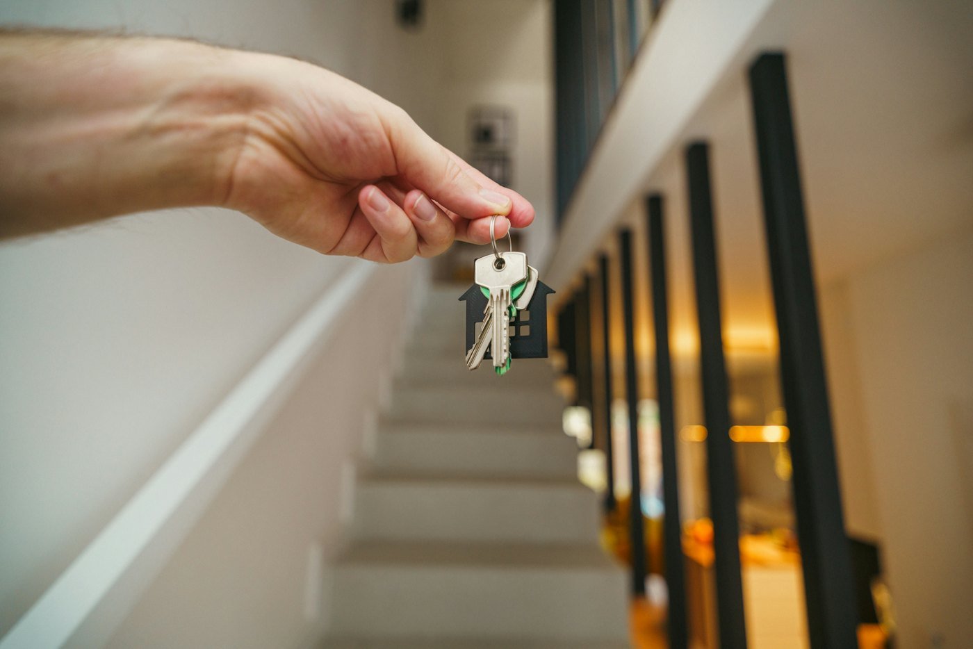 A hand holding out a bunch of house keys