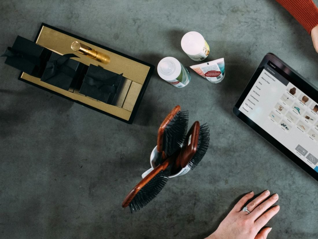 A shop counter with a till screen, brushes and products