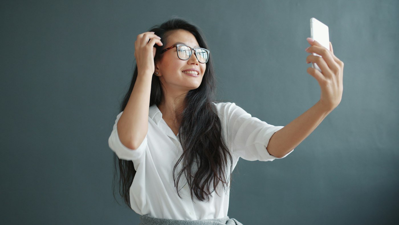A woman holding her phone up to take a photo of herself
