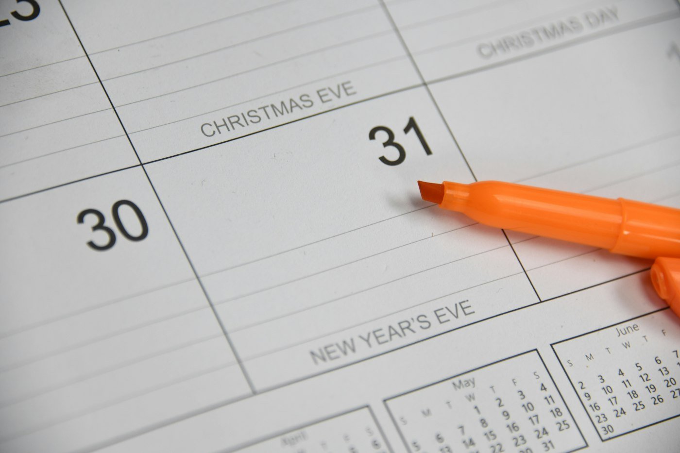 An orange pen resting on a calendar page