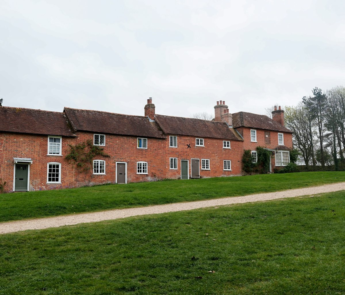 A row of red brick houses with green front doors