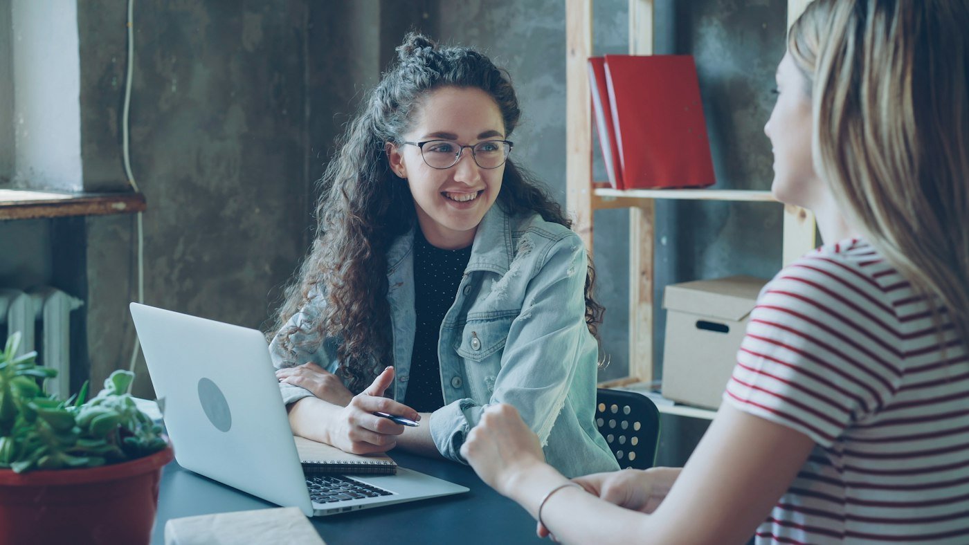 Two company directors talking over a laptop