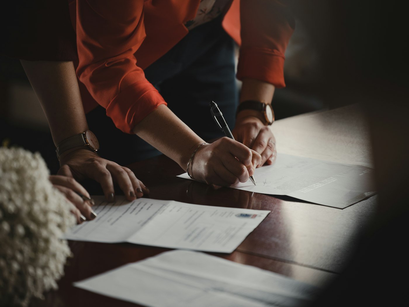 Hands going through paperwork with a pen