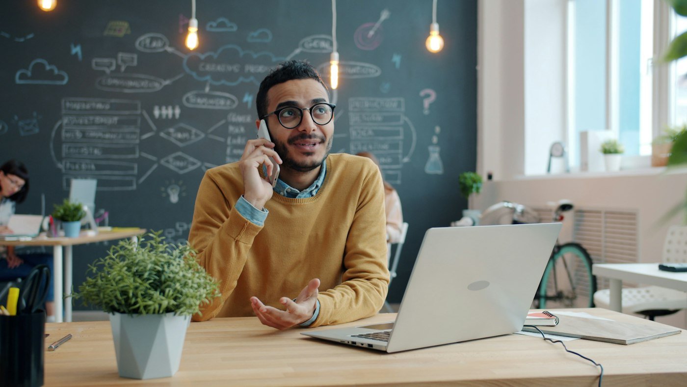 A business owner on the phone at his desk, going through his figures